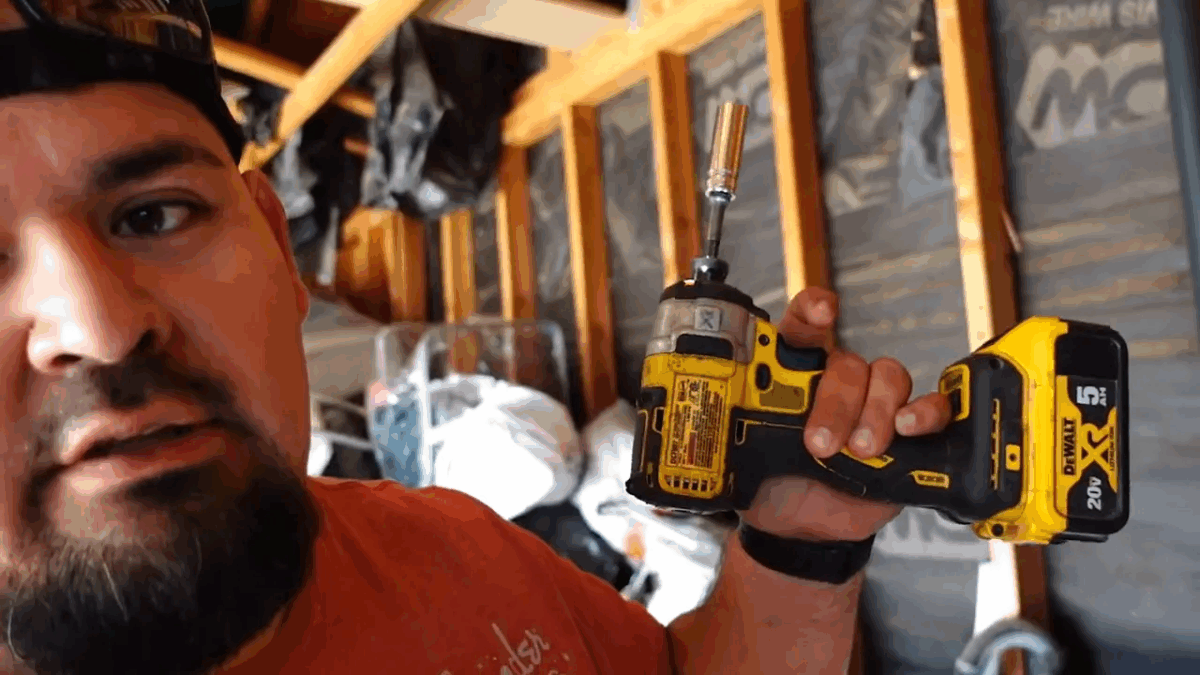 Best Tools to Fix Garage Door - A Practical Guide 5 Technician holding a ladder with an impact driver visible in truck